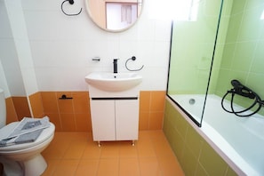 A bathroom with a white sink, a toilet, and a bathtub.
