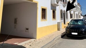 A white building with yellow trim and a black car parked in front. - Almograve House (Almograve)