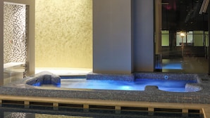 Un espace dédié à un bain à remous, doté d’un sol carrelé et d’un mur au motif texturé.