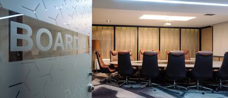 A conference room with a large table, multiple chairs, and a sign that reads "BOARD".