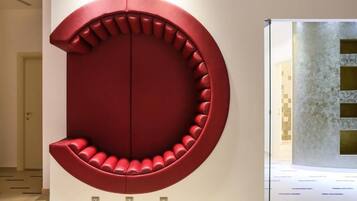 Un intérieur moderne avec un espace salon circulaire rouge et un mur à texture.