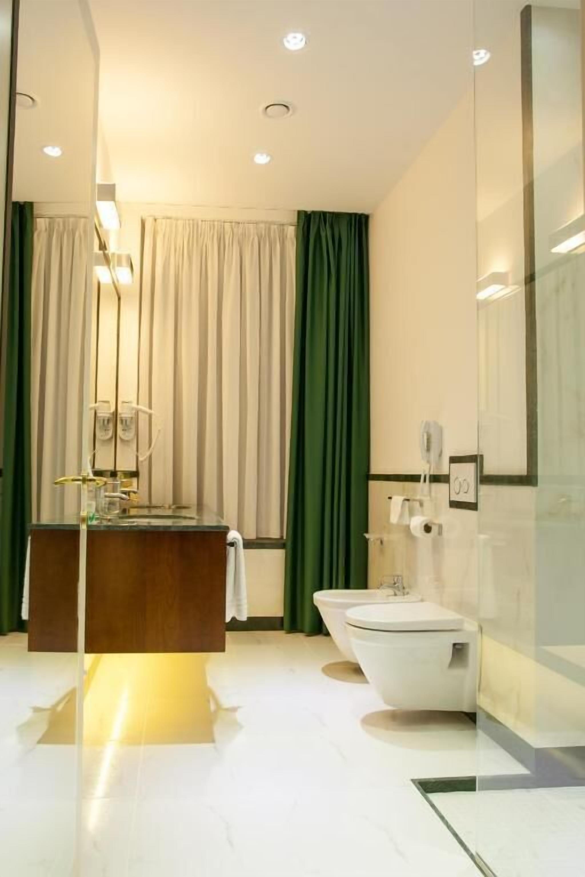 A modern bathroom with a freestanding bathtub, a vanity with a mirror, and a toilet.