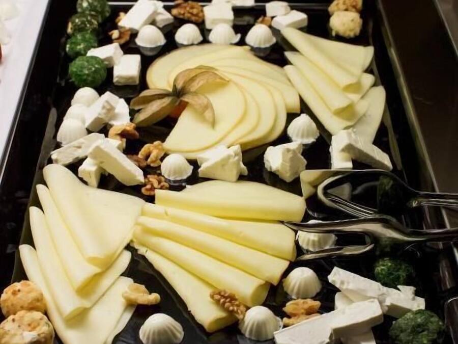 A buffet with various food items including cheese, nuts, and vegetables.