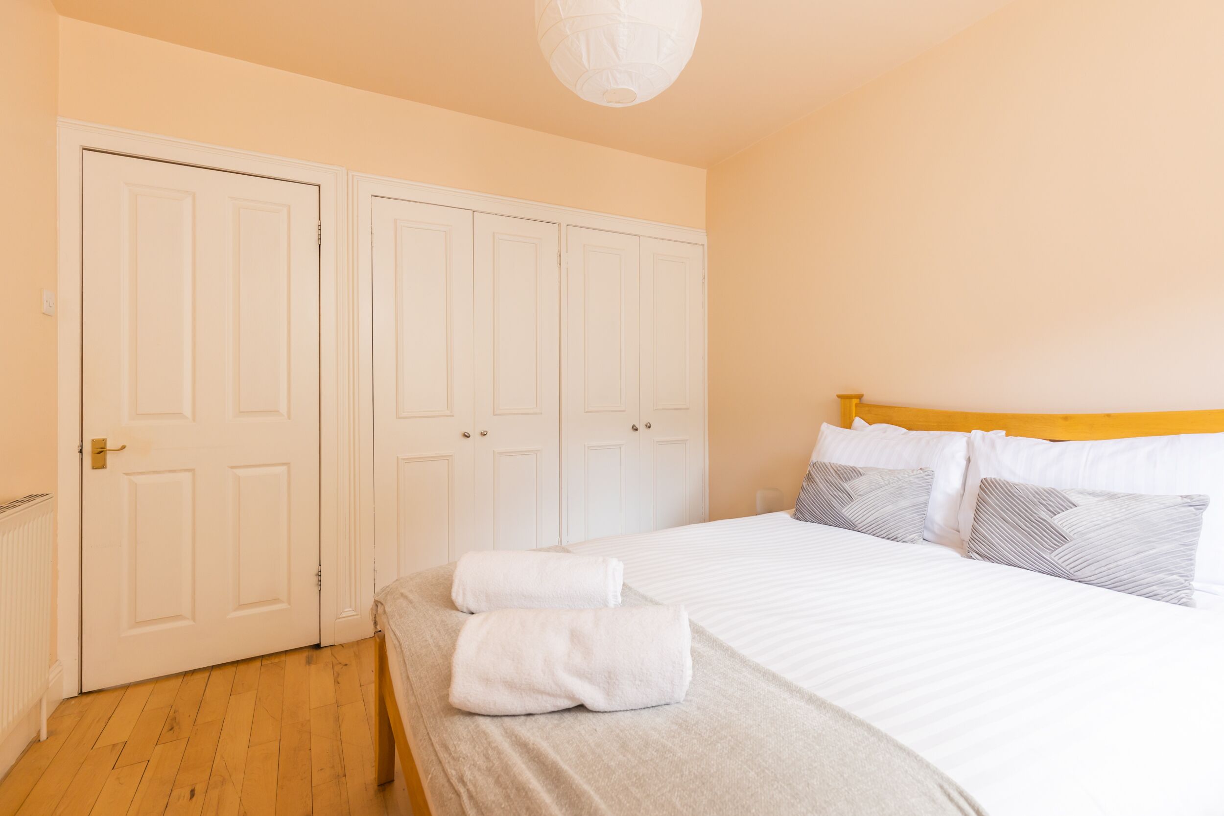 A bedroom with a bed, a wardrobe, and a radiator.