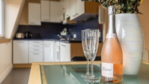 A glass table with a bottle of Italian Rose champagne and two glasses. - Amazing Castle View Apartment (Edinburgh)