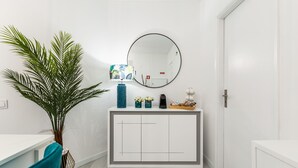 A hallway with a white console table, a large mirror, and a potted plant. - Paradise Porto apartment with terrace in the center of Porto (Porto)