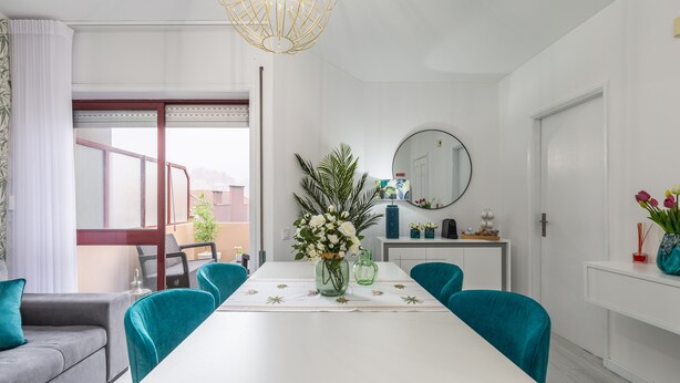 A modern dining area with a white table, teal chairs, and a vase of flowers. - Paradise Porto apartment with terrace in the center of Porto (Porto)