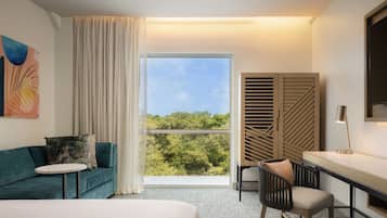 Een moderne hotelkamer met een groot raam, een bank, een bureau en een stoel.