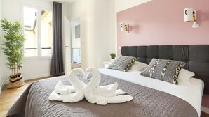 Et moderne hotelværelse med en stor seng, en rosa farvet væg og udsigt ud
