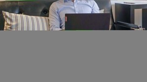 A room with a black leather sofa, a striped pillow, a laptop, a TV, and a bed with white bedding. - CCD Convenient Studio Only Blocks From Piedmont Hospital (Atlanta)