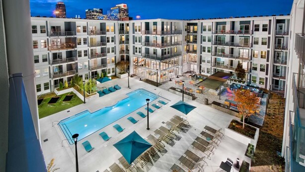 A modern apartment complex with a rooftop pool, outdoor seating, and a view of the city skyline. - S2ba Modern 2-br Walkable in Midtown 1 Block From Marta (Atlanta)