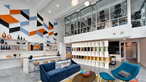 A modern interior with a blue sofa, a coffee table, and a colorful rug. - S2ba Modern 2-br Walkable in Midtown 1 Block From Marta (Atlanta)