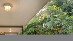 A hallway with a ceiling light, a door, and a wall with greenery. - CPH Secluded Studio Safe Serene and Serviced (Atlanta)