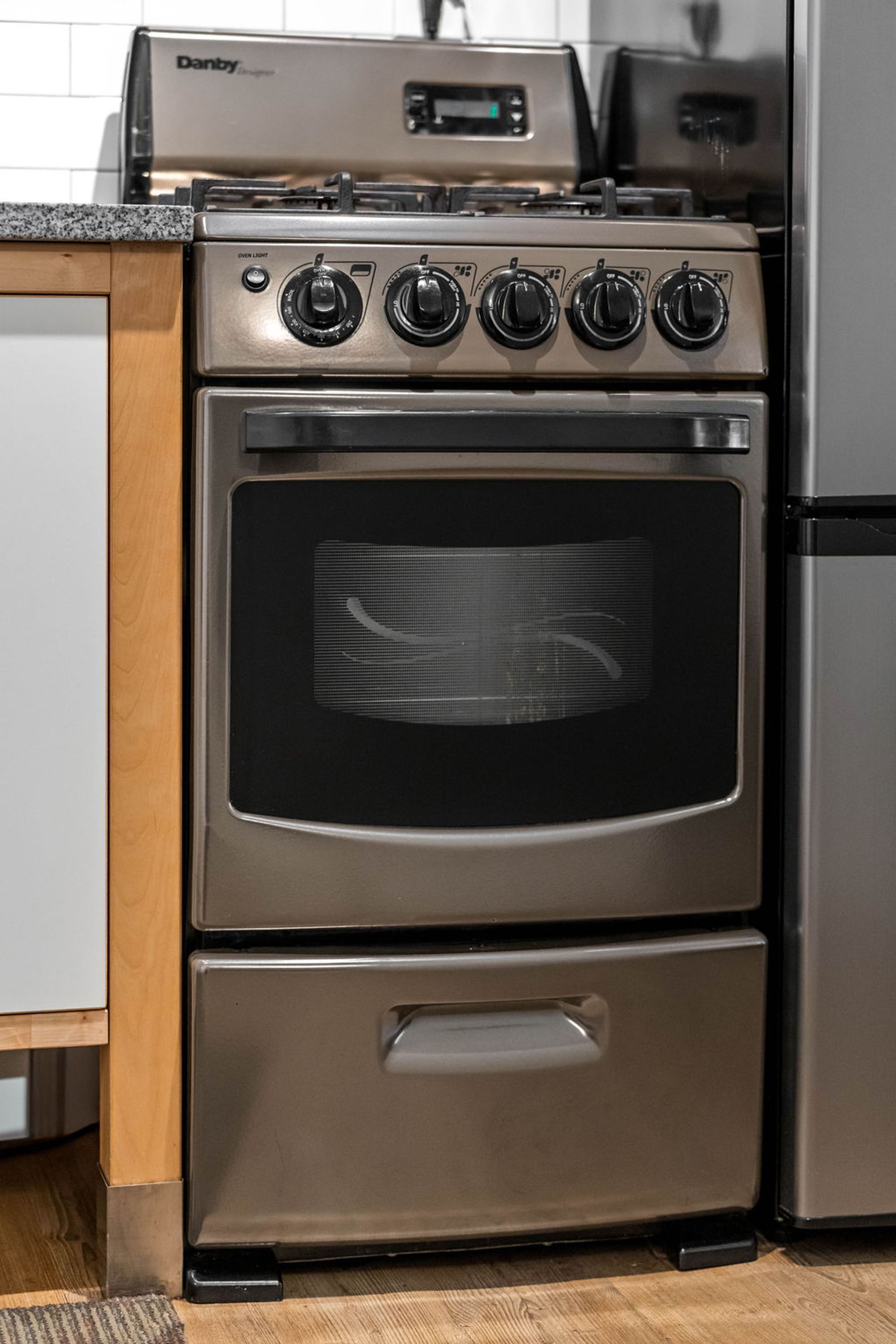 Une hotte de cuisine en acier inoxydable de la gamme « Dainty Designer », dotée de quatre brûleurs et d’une seule porte de four.
