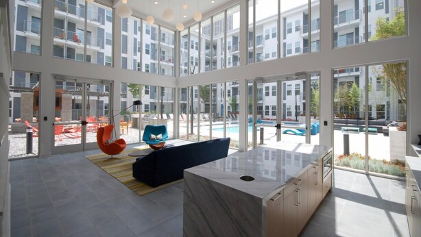 A spacious, modern interior with large windows, a central seating area, and a view of an outdoor swimming pool. - S1ba Hidden Gem Well Equipped 1-br Perfect for Business Travel (Atlanta)