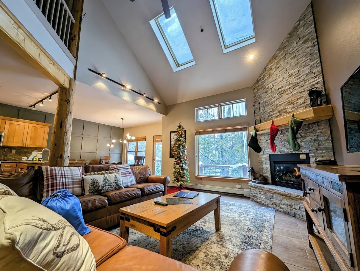 A spacious living room with a fireplace, a large window, and a cozy seating area.