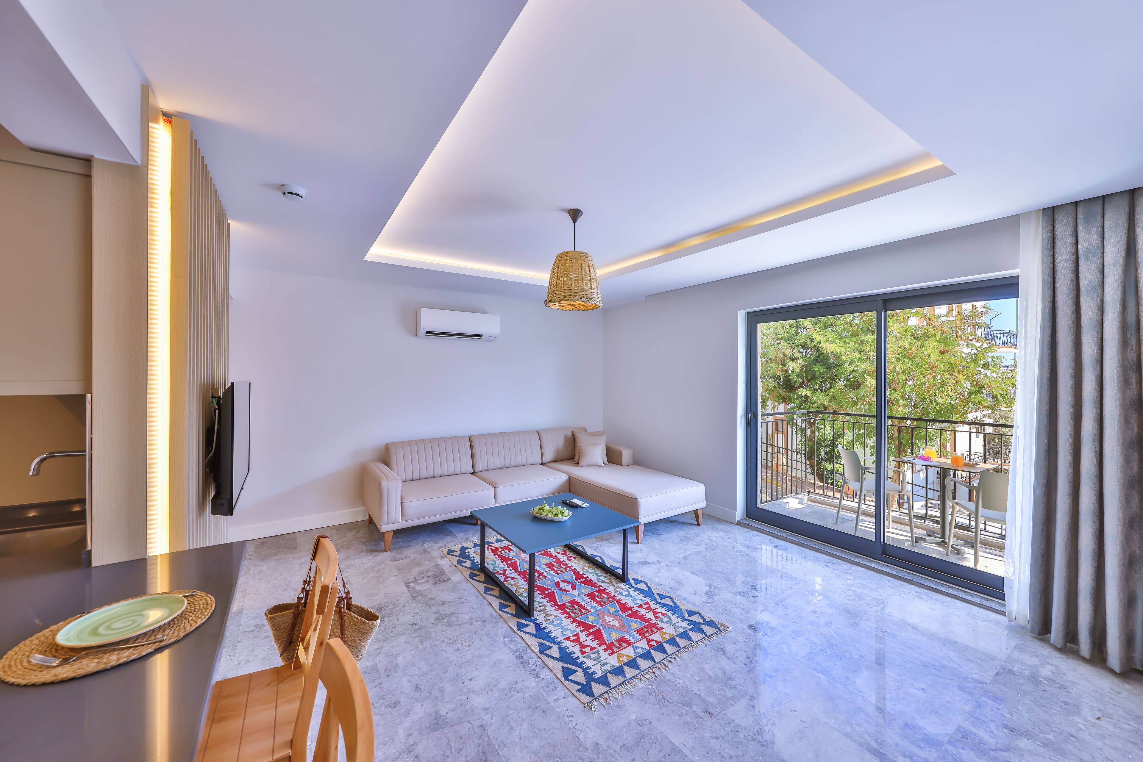 A modern living room with a sofa, coffee table, and a view of the outdoors.