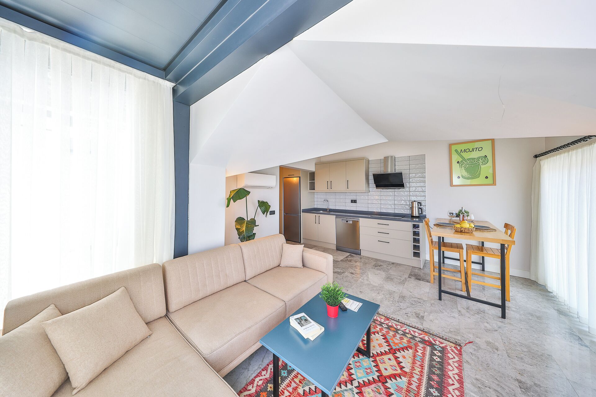 A modern living room with a sofa, a coffee table, and a dining area with a table and chairs.