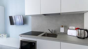 A modern kitchen with a built-in oven, a microwave, a sink, and a toaster.