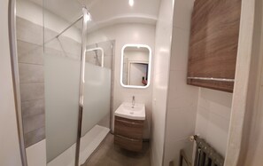 Een douche, een haardroger, handdoeken, toiletpapier