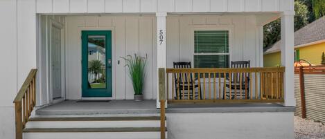 A two-story house with a front porch, a green door, and a number '507' on the wall.