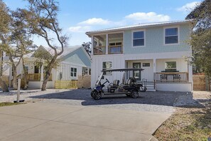 A two-story house with a covered porch and a golf cart in the driveway. - Newer- 5 Bedroom- Heated Pool and Spa (Saint Augustine)