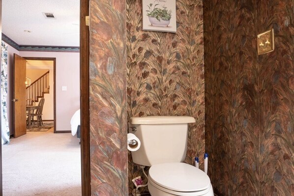 A bathroom with a toilet, a shower, and a sink.