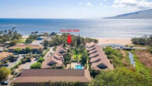 Une station balnéaire comprenant plusieurs bâtiments de style bungalow, une piscine et donnant sur la plage.