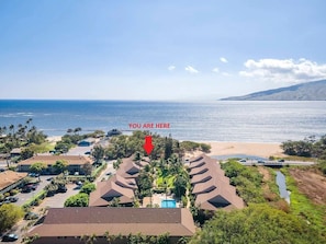 Ein Küstenresort mit mehreren bungalowsähnlichen Gebäuden, einem Swimmingpool und Blick auf den Strand.