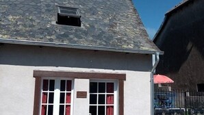 A building with a steeply pitched roof, a satellite dish, and a small window. - Gite Les Marmottes - Two Bedroom House, Sleeps 5 (Trémouille)