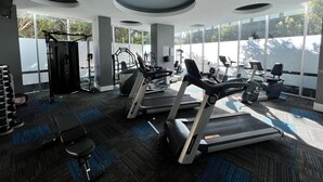 A modern gym with treadmills, elliptical machines, and weightlifting equipment. - Bliss By The Ocean beautiful views, walk to beach! (Surfers Paradise)