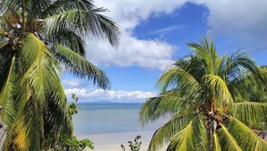 A beach with palm trees and a clear view of the ocean. - Villa Valiha Lodge (Nosy Be)