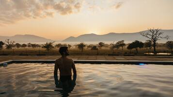 Guests can enjoy a serene pool experience surrounded by a natural landscape.