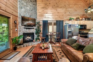 Un salon chaleureux avec une cheminée en pierre, un plafond en bois et un canapé en cuir.