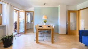 Un comedor con una mesa de madera, sillas y una lámpara colgante.