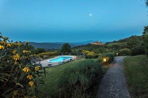 A pool area with lounge chairs and a stone pathway leading to a building. - Country Cottage (B) with pool - Le Caldanelle (Civitella Paganico)