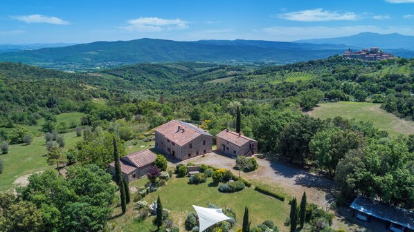 A rural property with a large stone building, a smaller adjacent structure, and a well-maintained garden.