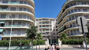 A multi-story residential building with balconies, a pedestrian walkway, and a gated entrance. - Le Métropole (Nice)