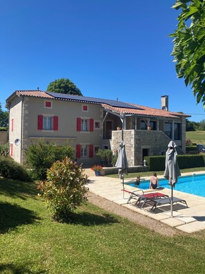 A two-story house with a swimming pool, red shutters, and a stone facade. - Small single-storey apartment with PRM access, 2*. (Caylus)