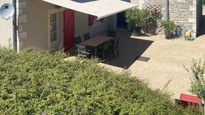 Una casa con patio, una mesa de comedor y una zona de estar techada.