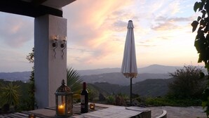 An outdoor dining area with a table set for two, a candle, a bottle of wine, and a lantern. - Amazing villa, superb views, close to village, private pool (Canillas de Aceituno)
