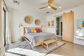 A modern bedroom with a bed, ceiling fan, and decorative wall art. - Backyard Oasis w/ Pool! Family Getaway in Phoenix (Phoenix)