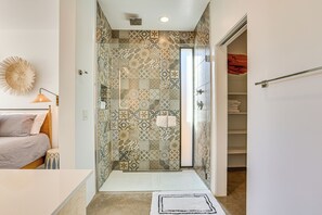 A bathroom with patterned tiles, a shower, a glass door, and a towel rack. - Backyard Oasis w/ Pool! Family Getaway in Phoenix (Phoenix)