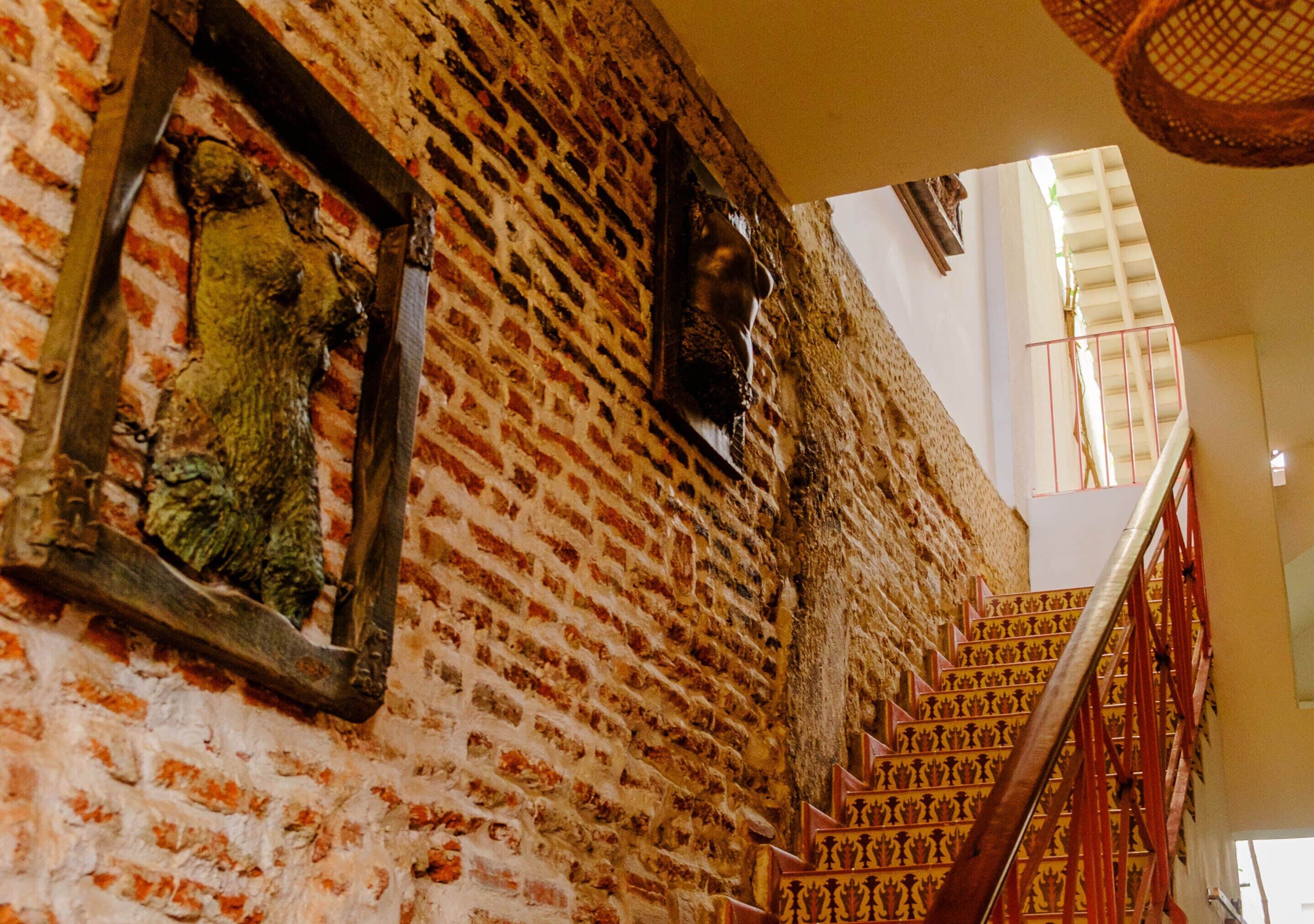A staircase with ornate railings and a brick wall with decorative elements.