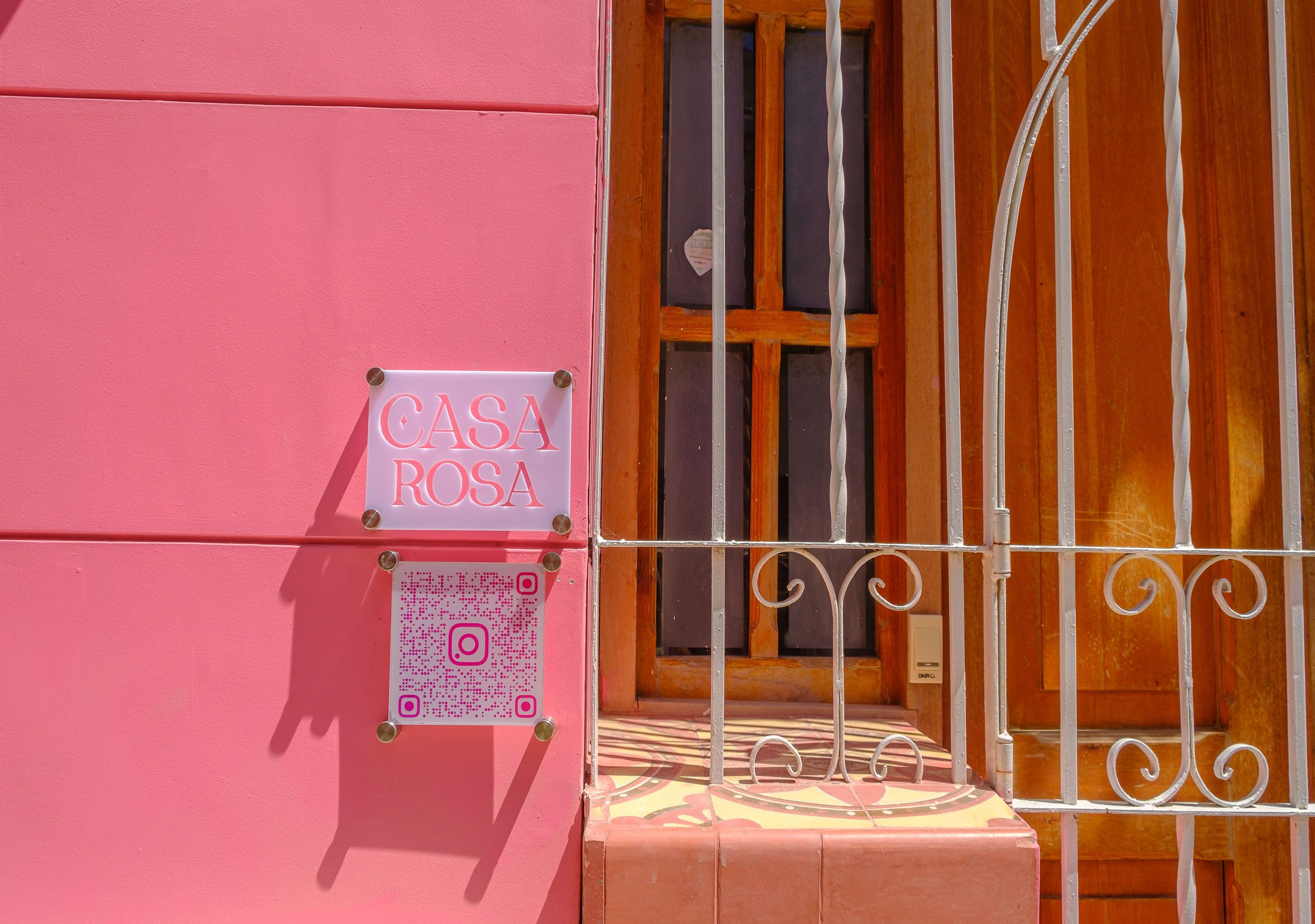 A pink building with a sign reading "CASA ROSA" and a QR code.
