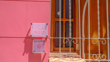 A pink building with a sign reading "CASA ROSA" and a QR code.