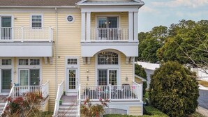 Un bâtiment à deux étages doté d’un balcon à l’étage supérieur, d’une entrée principale et d’un petit porche.