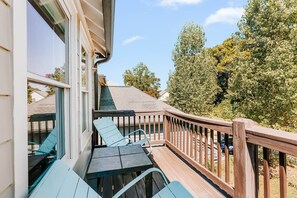 Eine Terrasse mit Tisch und Stühlen, mit Blick auf einen Garten mit Bäumen.