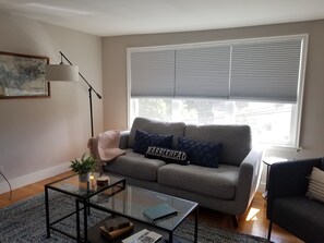 Relax in this stylish living room with a grey sofa, coffee table, and floor lamp.