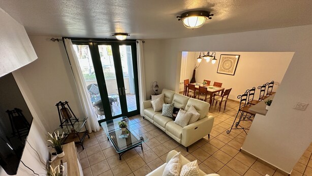 A living room with a sofa, coffee table, and a dining area with chairs and a table. - Enjoy the beautiful beach villa of Boqueron. Relax in stress-less beach ambiance (Boquerón)